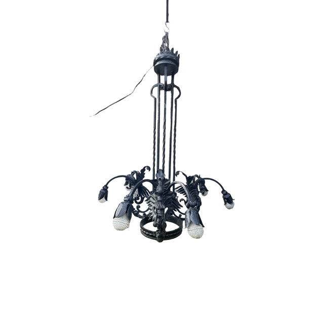 Extraordinary large-scale hand forged wrought iron chandelier, featuring sculptural dragon/grotesque motifs, scrolling...
