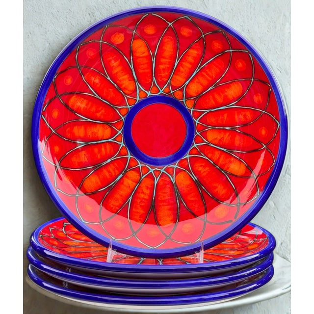Presenting a set of four made in Italy, hand painted and glazed terra cotta plates. In vibrant colors of the sunset with...
