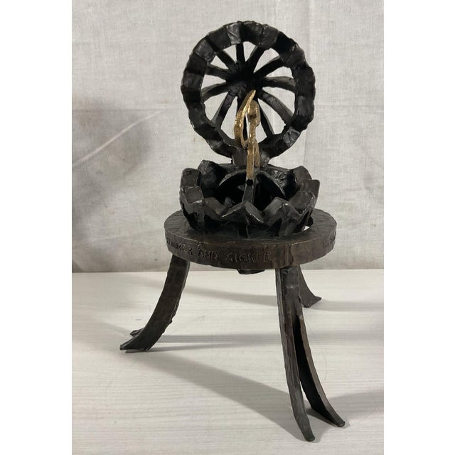 Faberge Egg with Hammer and Sickle is a bronze sculpture of a cracked-open egg holding a gold-toned hammer and sickle, on...