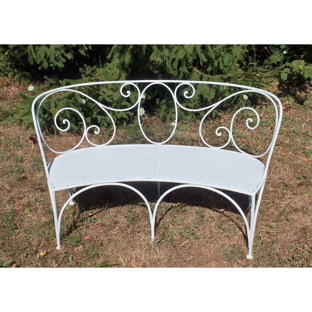 Curved wrought iron bench, lacquered white, backrest decorated with wrought iron scrolls, seat made of thick iron plates...