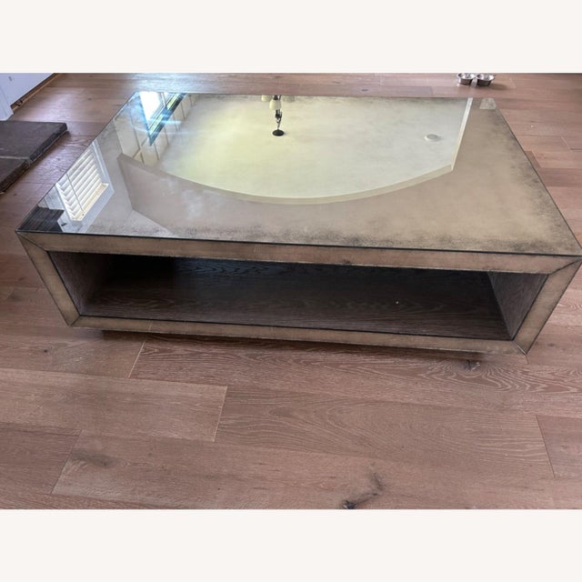 The Sutherland cocktail table pairs oak veneers with antiqued mirrored glass to create an elegant modern look. Rectangular...