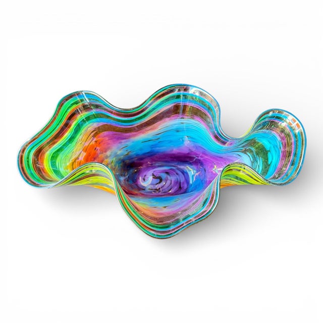 A striking large-scale art glass bowl featuring a dramatic freeform silhouette and vibrant multicolor swirled design. This...