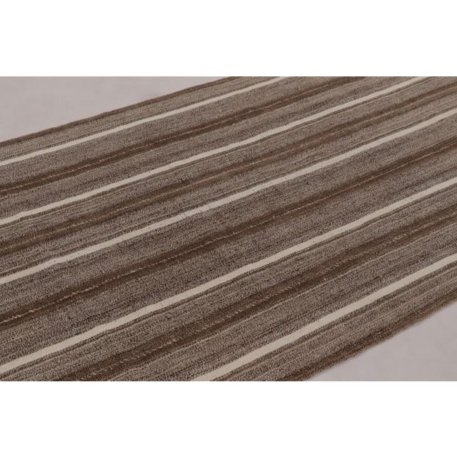 Handwoven in wool and originating circa 1950-1960, this 5x8 vintage Persian kilim is a rich tribal curation among the new...