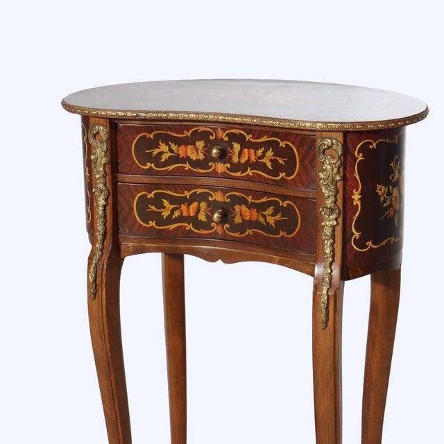 A 20th-century French kidney-shaped stand, crafted from rosewood with intricate marquetry and adorned with ormolu mounts....
