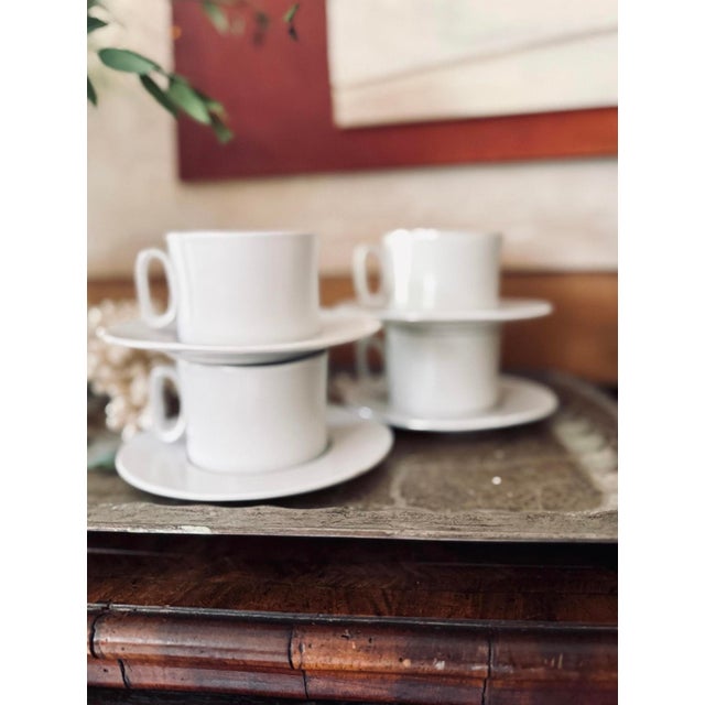 Bennington pottery set of four coffee mugs with their matching saucer, presented in a soft creamy glaze over a beige...