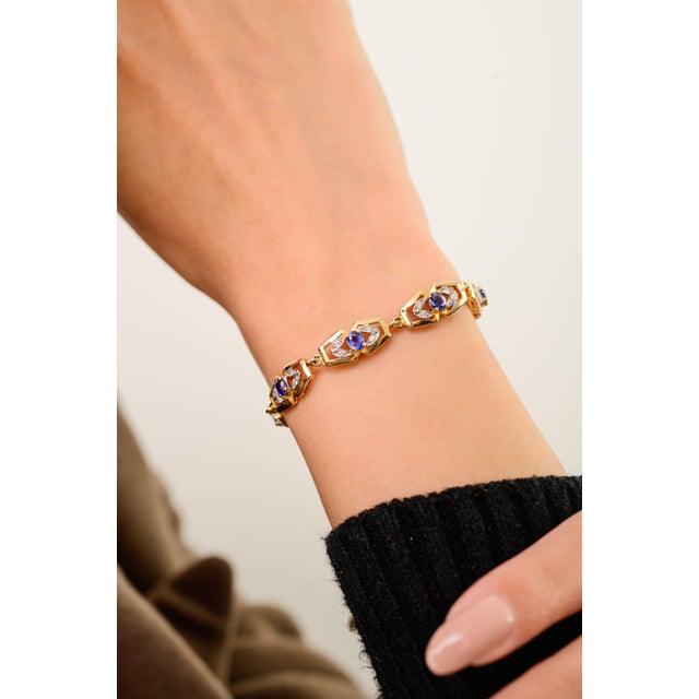 This elegant art deco-style link bracelet features oval cut blue sapphire totaling 1.65 carats, set in 18k yellow gold....