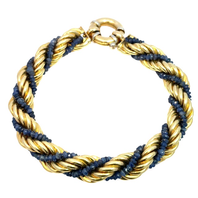 Elegant 18k yellow gold rope-design bracelet wrapped with rich blue sapphire beads. This beautifully weighted bracelet...