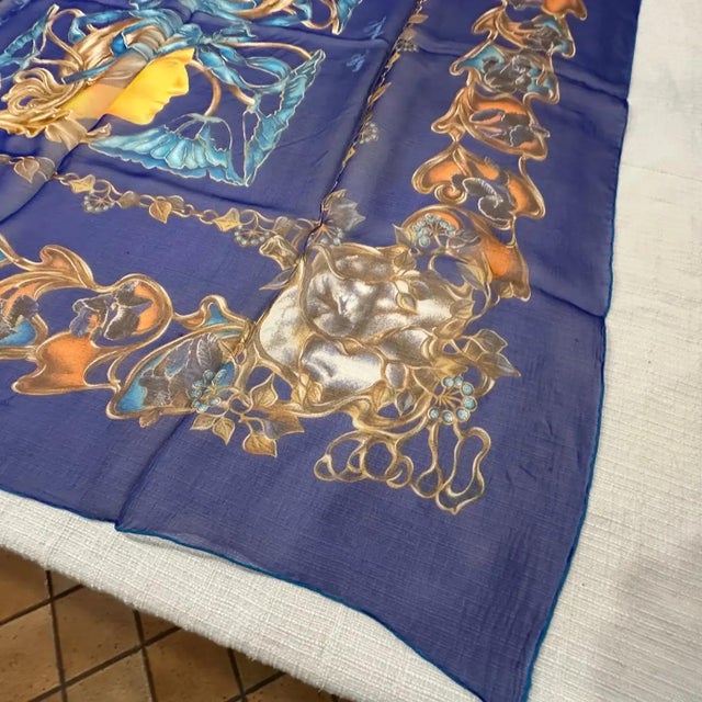 This is an exquisite silk scarf from Lalique, featuring a rich, deep blue background. The design is highly ornate and...