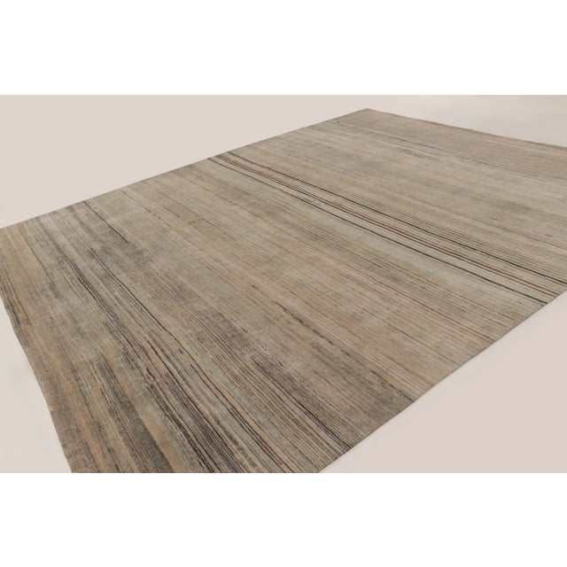 This oversized 12x14 contemporary solid and stripes rug, handwoven in wool and natural silk, features a softly striated...