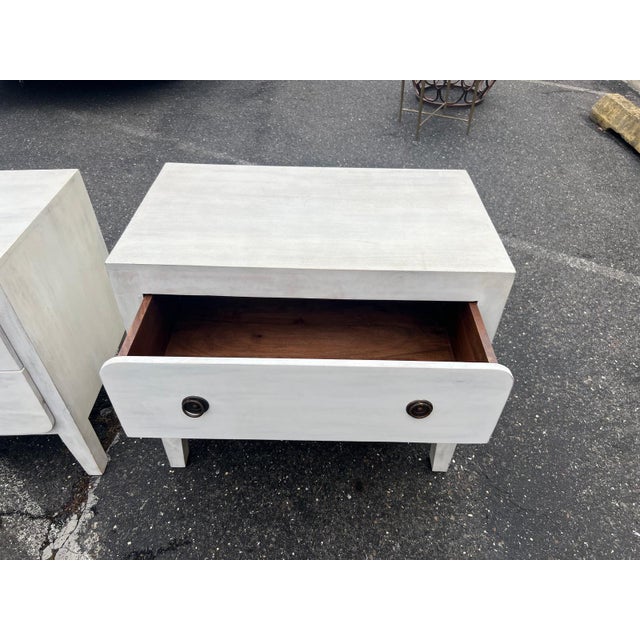Stylish pair of chunky two-drawer nightstands crafted circa 2010s in the Organic Modern / Coastal style, featuring a light...
