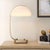Showcasing A Captivating Minimalist Design, This Desk Lamp Features A Gracefully Curved Antique Brass Plated Frame That...