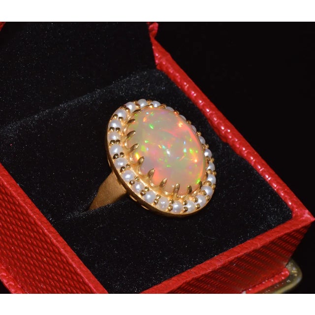 Gorgeous 18K solid gold 2.40CTS natural seed pearls and 11.38CTS natural opal cocktail ring. This ring features a huge...