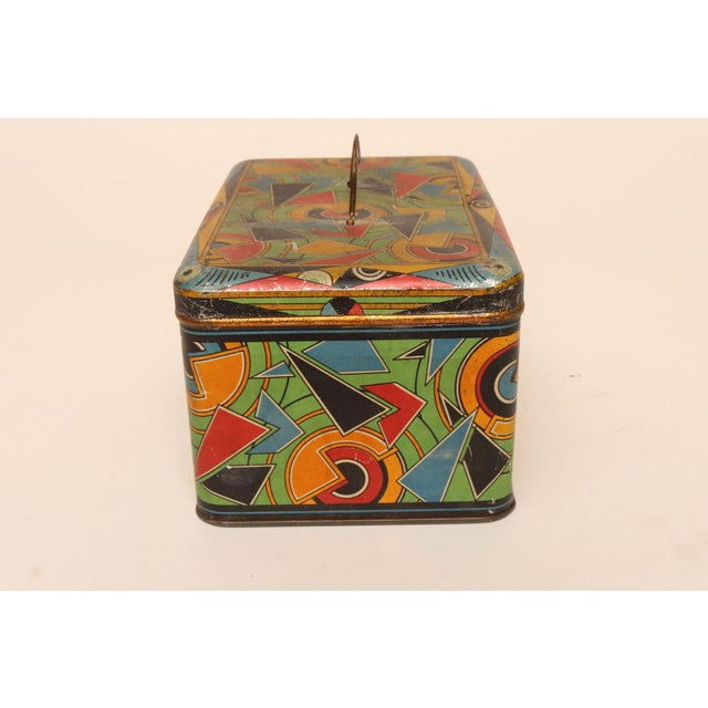 Bauhaus-style tin box with geometric shape motif in a vibrant palette of blue, yellow, black, green, and red (ca. 1930s,...