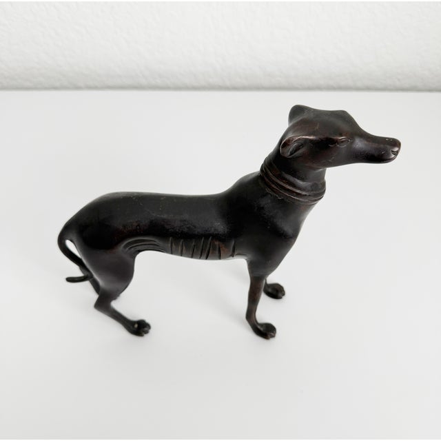 Produced in the Mid-20th century in the Art Deco style, we present this handsome greyhound or whippet dog figurine statue...