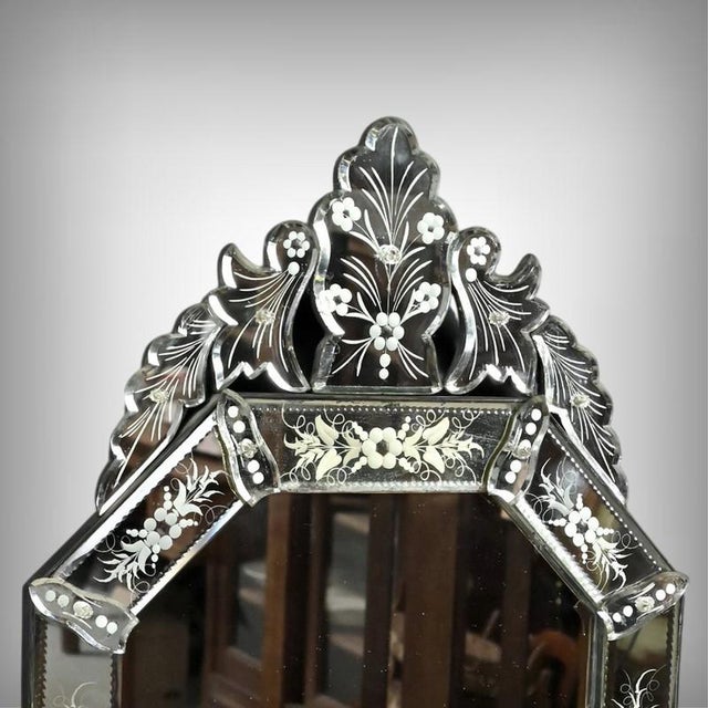 with its sculptural elegance, this Venetian mirror is distinguished by its engraved glass frame, adorned with finely...