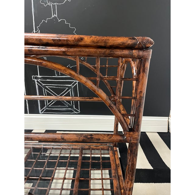 A stylish, tropical boho-inspired accent side table or nightstand featuring a dark tortoiseshell patterned bamboo/rattan...