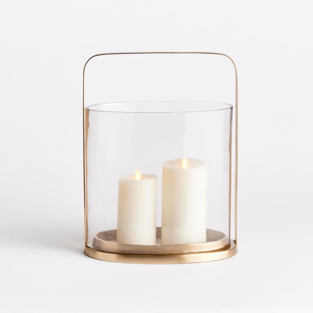 With a rare oval shaped glass hurricane, this unique candleholder is a work of art. The simple design and warm matte brass...