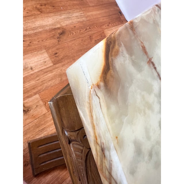 Elegant and solid table with a decorative onyx marble top and a Wilhelminian-style wooden frame. The table likely dates...