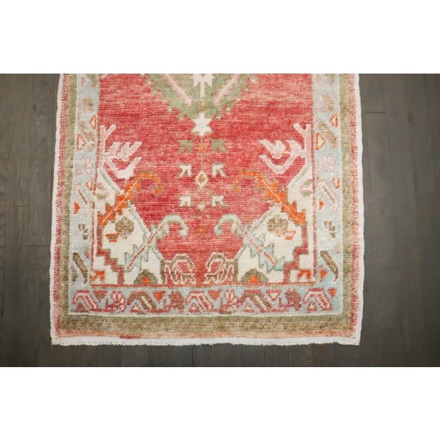 A Vintage Turkish anatolian ug with an off center medallion on a red field.
