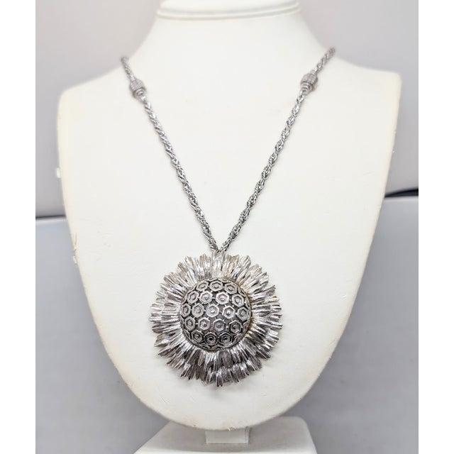 1960s rhodium plated round domed honeycomb center with ruffled "burst" surround pendant on a chain with hatched detail...
