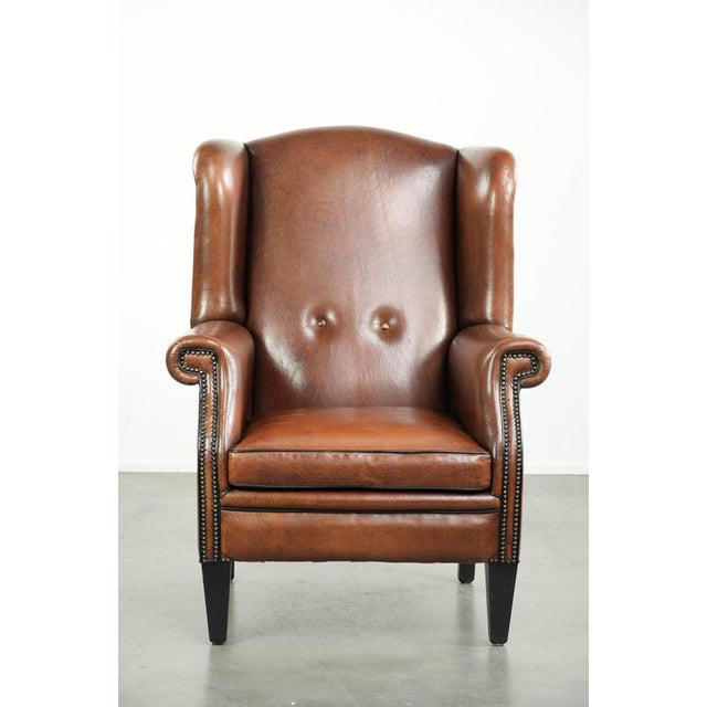 This luxurious sheepskin wingback chair is beautifully finished with black piping and decorative studs. The lining under...