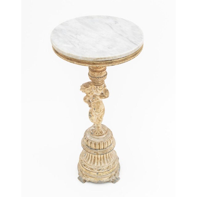 Neoclassical Style Marble Top Figural Side Table, the circular gray marble top above painted metal cherub figure standing...