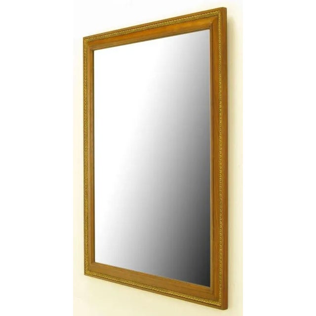 Understated and elegant wall mirror from Kindel Furniture. Bleached walnut frame with parcel gilt gesso inlaid detail....