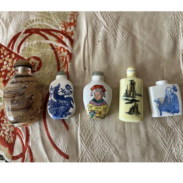 A fine collection of five vintage Chinese snuff bottles, featuring a variety of materials and classical motifs. This lot...
