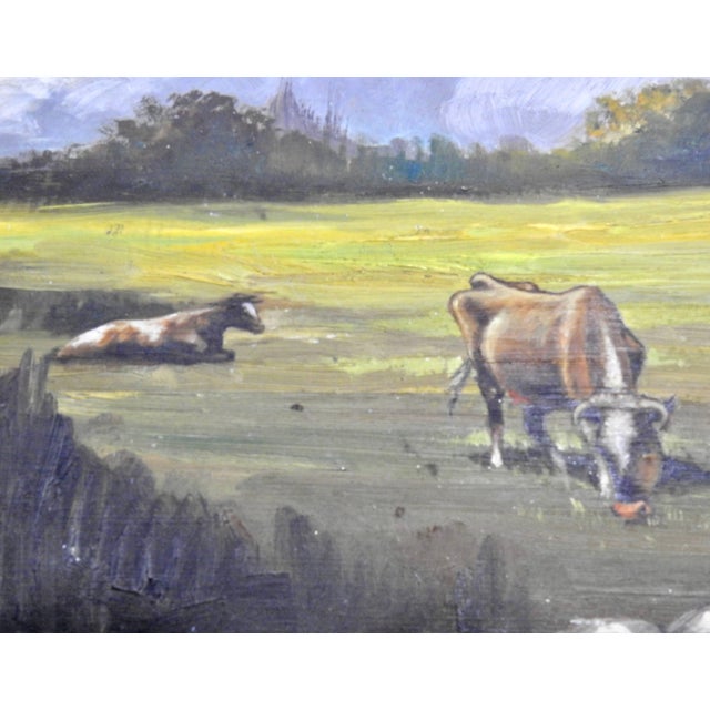 Fluffy clouds in the blue sky are hovering over the cattle in the colorful field of grass. Trees line the background and...