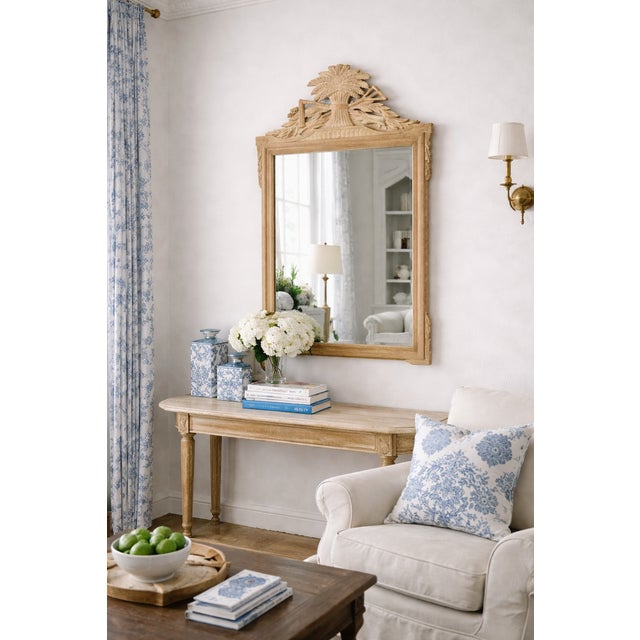 An elegant Louis XVI–style wall mirror featuring a finely hand-carved sheaf of wheat crest flanked by gracefully draped...