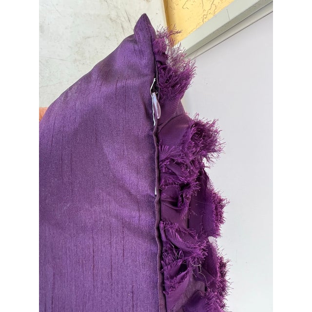 Pillow in solid deep purple color. Has purple fabric flowers on one side. Invisible zipper with feather pillow insert.