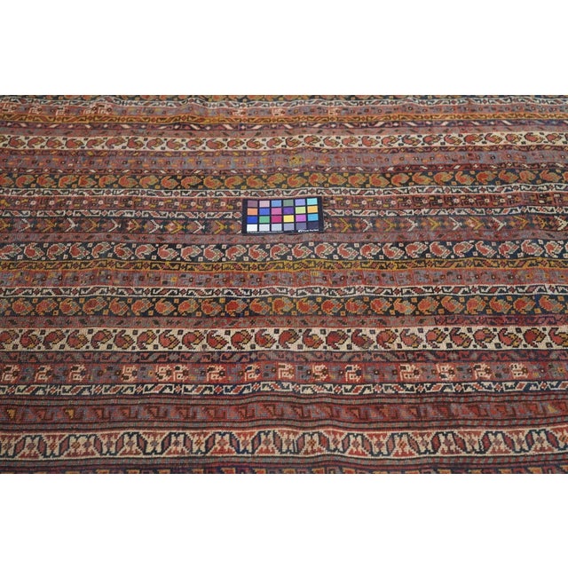 This west Persian village scatter on a wool warp displays the popular “cane” textile pattern of narrow vertical stripes...