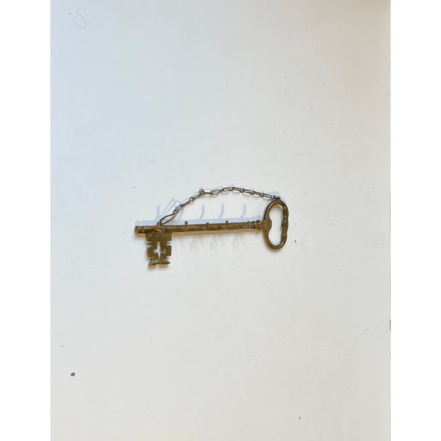 A decorative key holder - rack made from an old large brass key. Shaped as a giant key and has 4 hooks. European made...