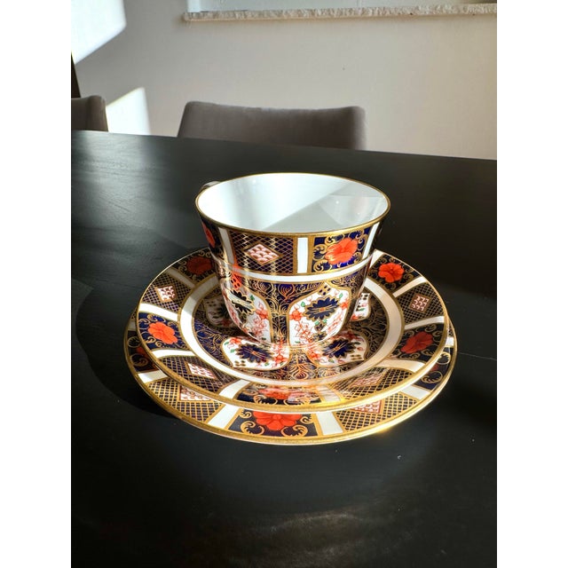 An exquisite vintage Royal Crown Derby Old Imari 1128 tea trio, featuring a teacup, saucer, and matching tea plate crafted...