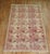 A mid 20th century Russian Karabagh Accent Size rug with brown and beige accents on a pink field Measures: 4'6'' x 7'8''.