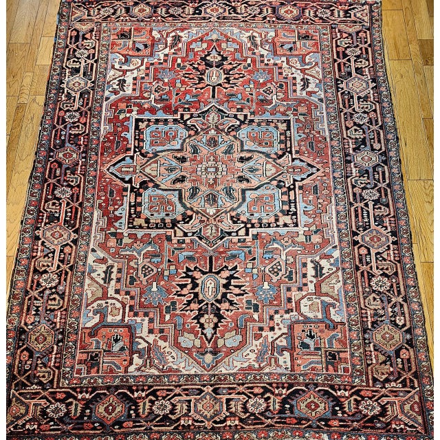 "This exquisite early 20th-century Persian Heriz rug features the coveted Serapi design and a striking room-size format,...