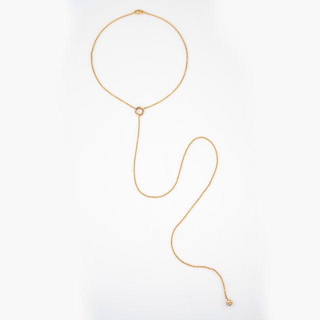 Stylish and finely detailed pre-owned Cartier "Pampilles" lariat necklace crafted in 18k yellow gold (circa 2000s). A...