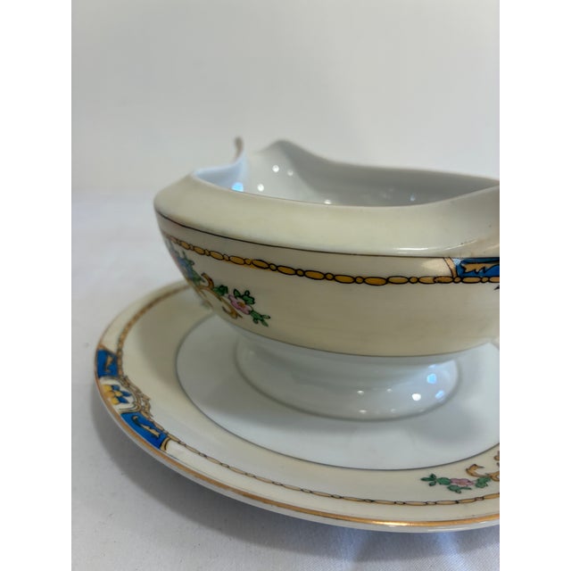 Hand-painted porcelain gravy boat by Meito China, made in Japan and marked “Warren” on the base. The boat is attached to...