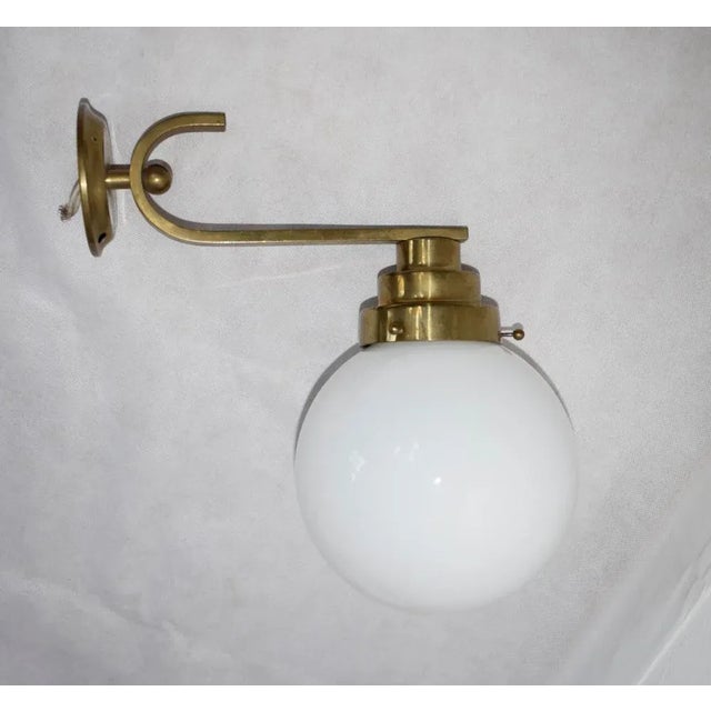 A few large wall lamps in Bauhaus style. Brass and opal glass. Diameter opal glass ball is 16 cm Up to 250V (Europe/UK...