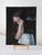 The artwork depicts a contemplative figure lost in thought, with hands clasped in front of her face, creating an intimate...