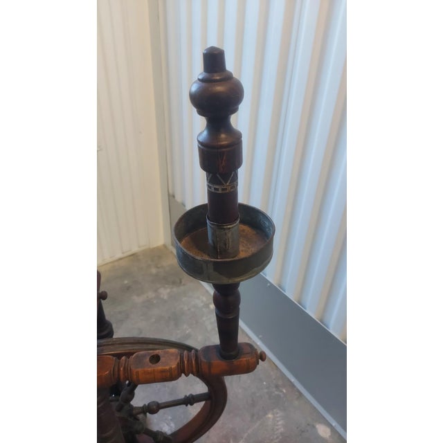 A beautiful and complete antique Swiss spinning wheel, dating to the 18th or early 19th century. Crafted from walnut and...