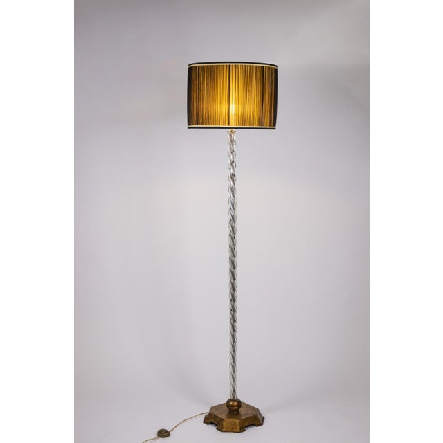 Maison Baguès twisted glass floor lamp with gilt metal base. French work realized in the 1950s. This piece is designed in...