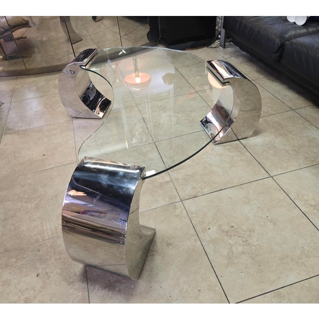 Fantastic vintage coffee table, kidney shaped glass with chrome leg stands. The stands can be adjusted in different places...
