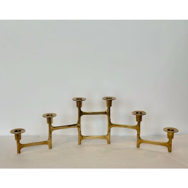 We are very pleased to offer a striking articulated brass candelabra, circa the 1960s. This piece features a sculptural,...