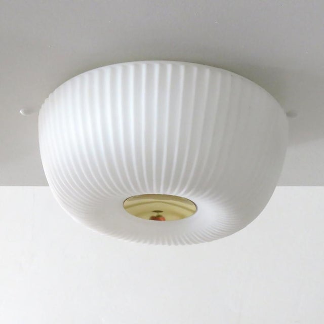 Elegant, opaline glass ceiling flush mount by Limburg Leuchten Germany, 1960, with a circular brass center and organically...