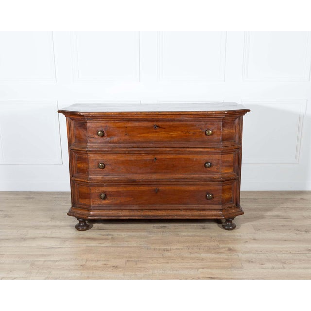 A handsome 17th-century Italian chest of drawers in solid walnut, notable for its sculptural, molded façade and warm,...