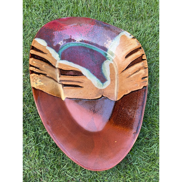 Large signed studio pottery platter with an organic freeform shape and layered oxblood, brown, purple, and turquoise...
