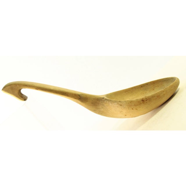 A finely crafted treenware large spoon or ladle One piece of wood with integral curved handle with a hook for hanging or...