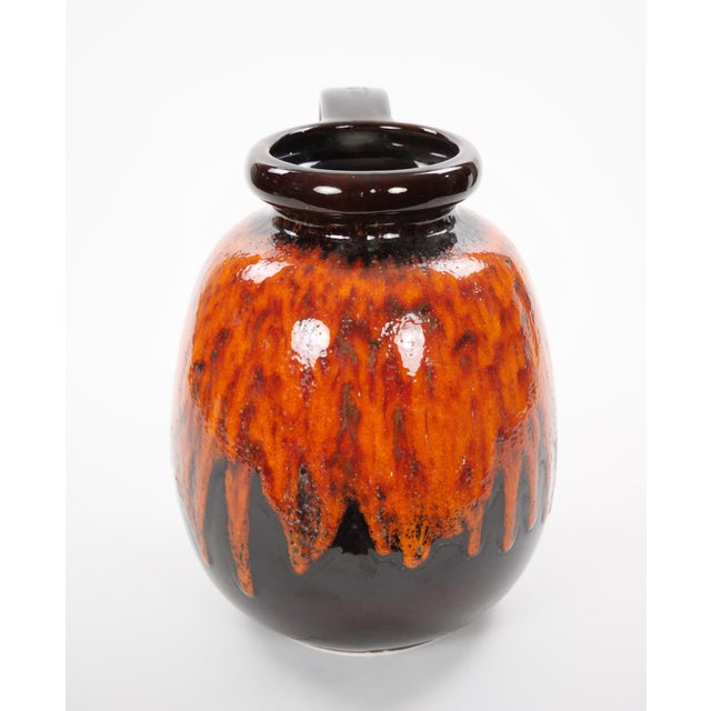 A striking mid-century West German drip lava glazed porcelain vase, beautifully showcasing the bold colors and modernist...