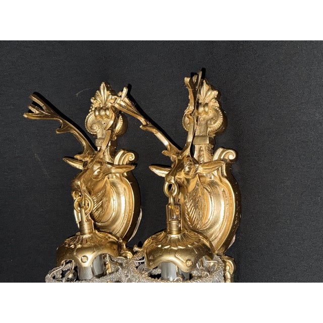 A distinctive pair of late 20th-century French Louis XVI-style gilt bronze deer head wall sconces, beautifully crafted...